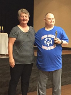 Coach Rita Arthur, left, awards a trophy to Bob Havens, right, during the Scioto County Special Olympics Banquet, June 1 at the SOMC Friends Center.